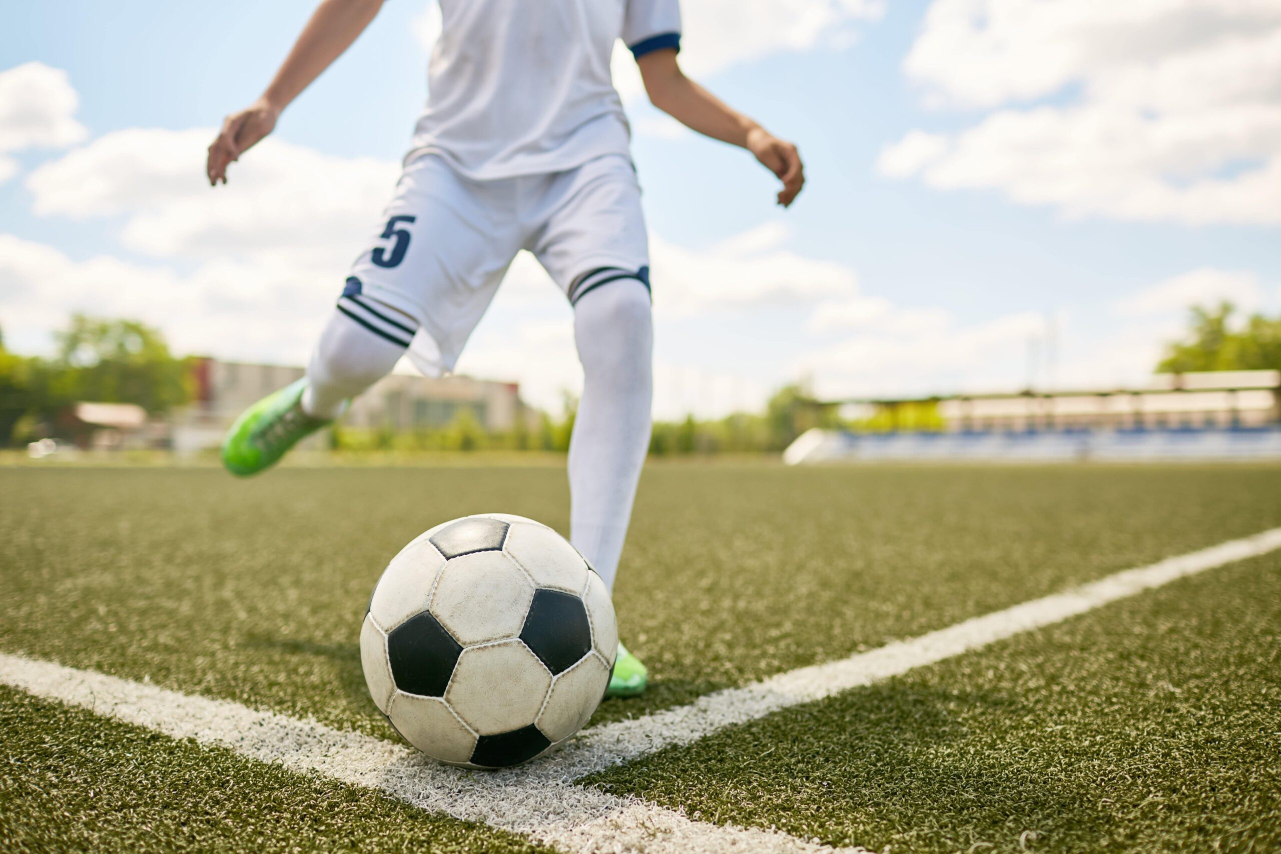 6235ea7fbaf601e8d3980228_boy-kicking-ball-on-football-field-2021-09-24-03-47-56-utc-min-min